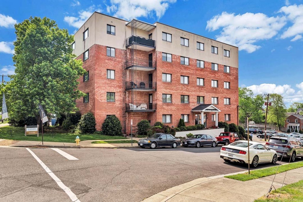 a brick apartment building with a parking lot in front of it