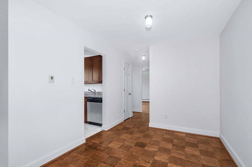 a bedroom with a bed and a kitchen in the background