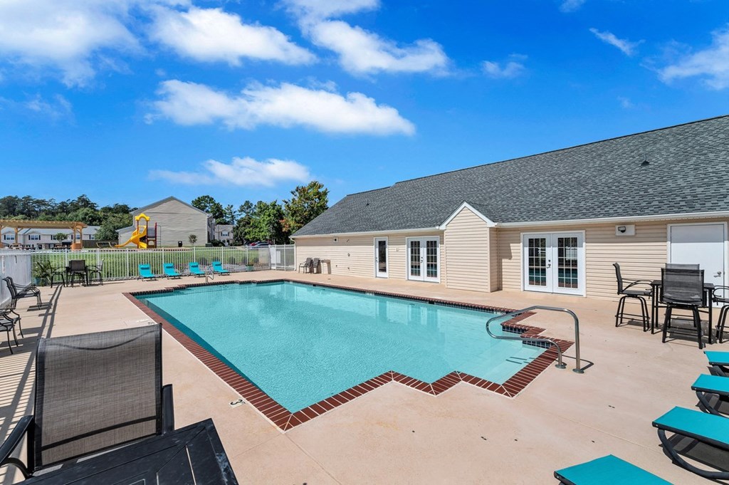 our resort style pool is open to the community and is surrounded by chairs and tables