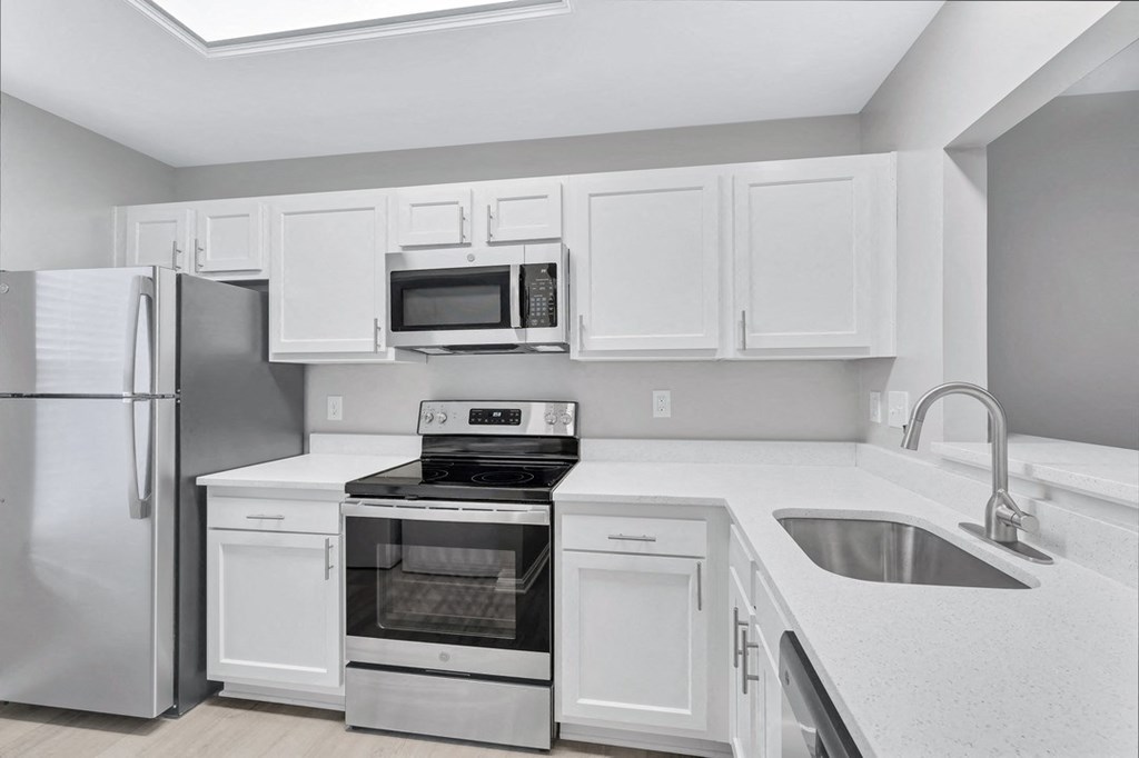 a kitchen with white cabinets and stainless steel appliances