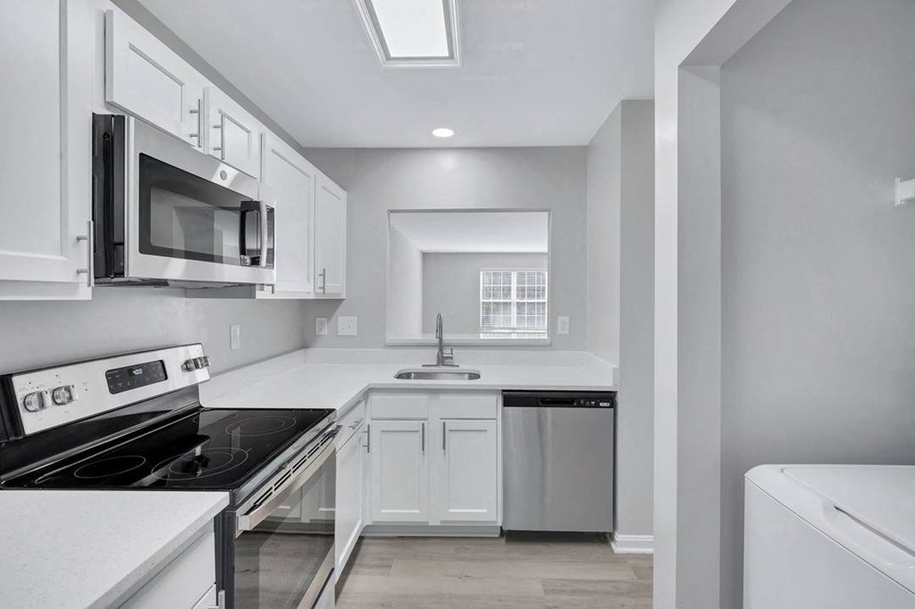 a white kitchen with a stove and a microwave