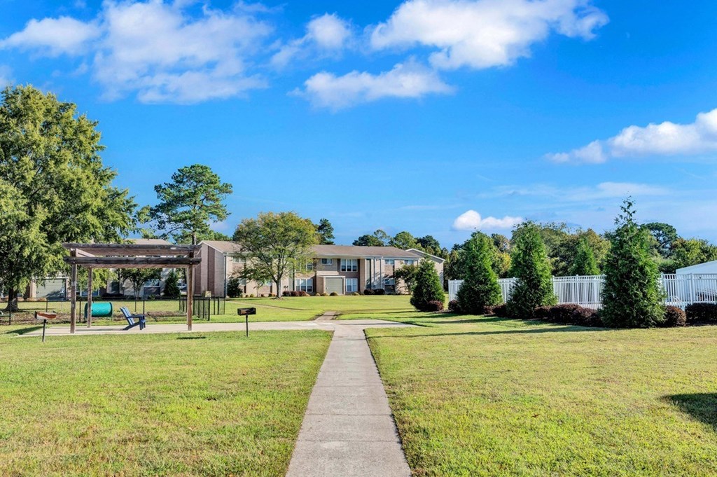 a pathway leads through a grassy area in front of a mobile home