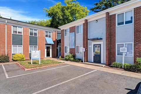a brick building with blue siding and a white sign in front of it