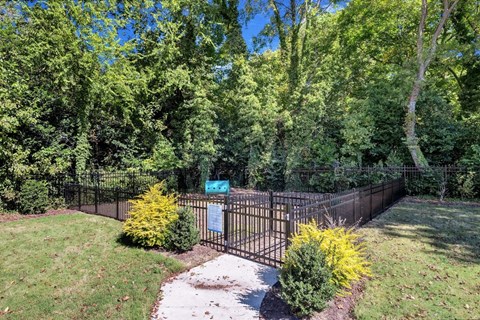 a black wrought iron fence in a yard with trees in the background