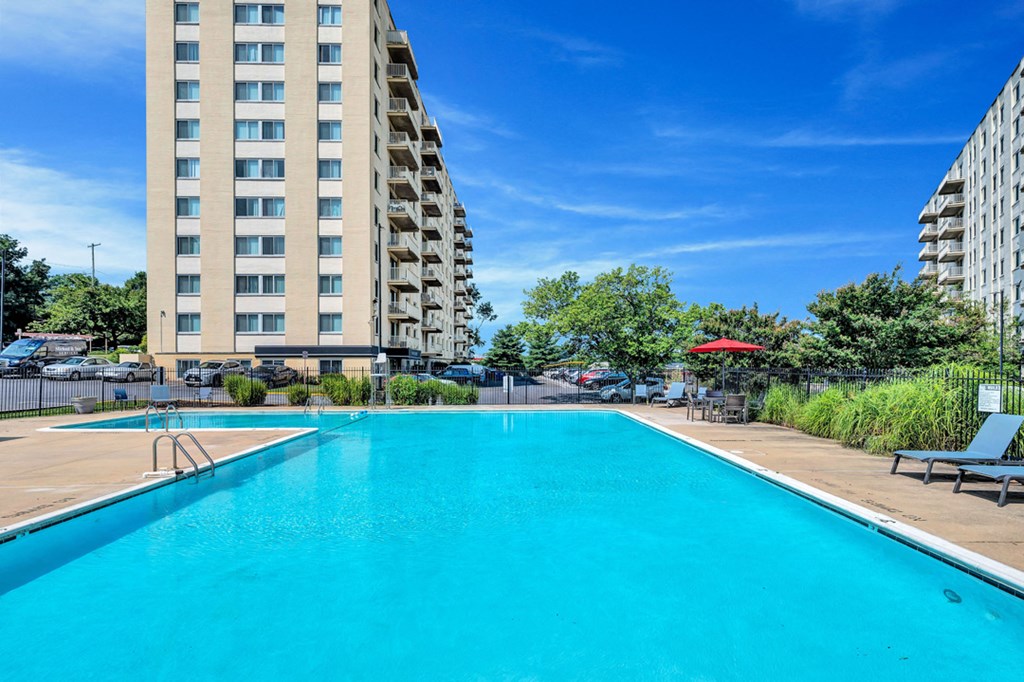 a swimming pool with an apartment building in the background