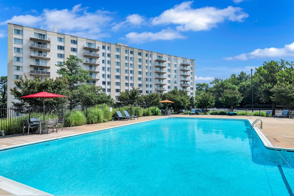 a swimming pool with an apartment building in the background