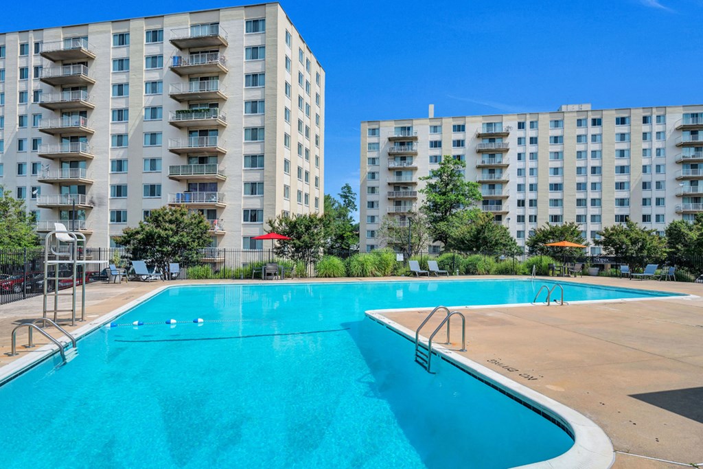 a swimming pool with an apartment building in the background