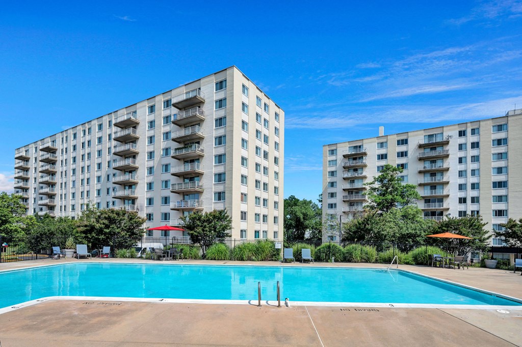 a swimming pool with an apartment building in the background