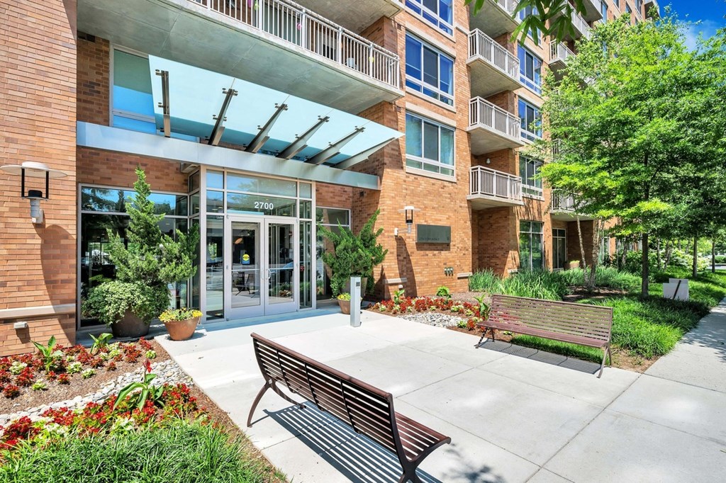 a courtyard with benches and a building with glass doors
