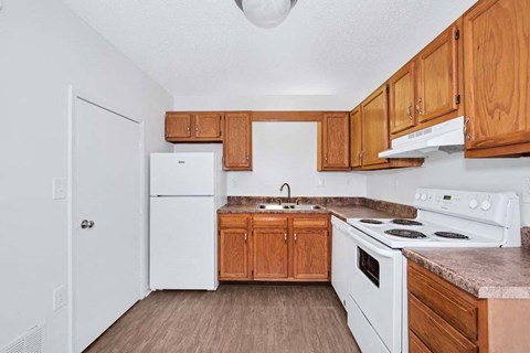 a kitchen with white appliances and wooden cabinets