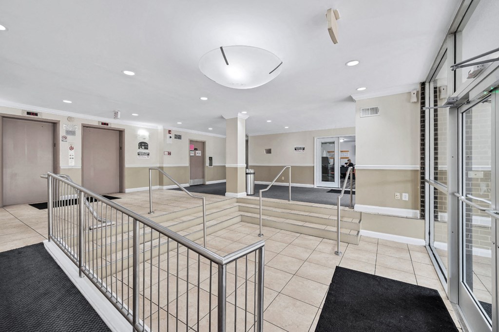 a large lobby with stairs and glass doors