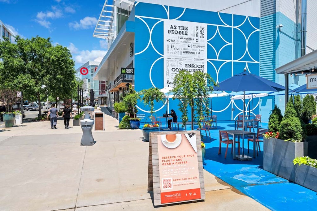 a city street with a blue building in the background and a sign