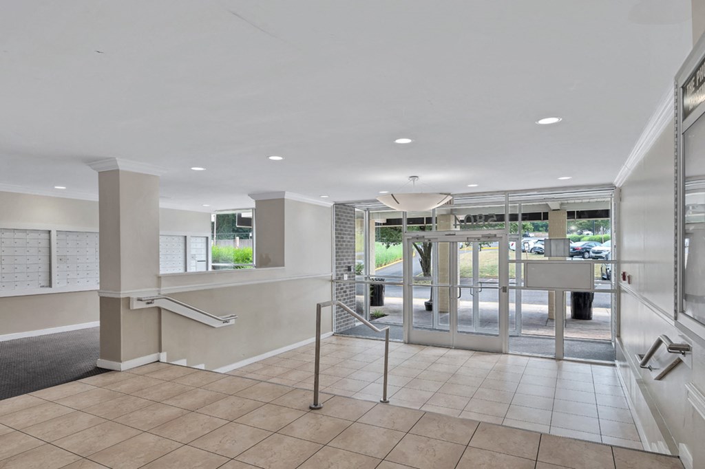 a lobby with a staircase and a glass door