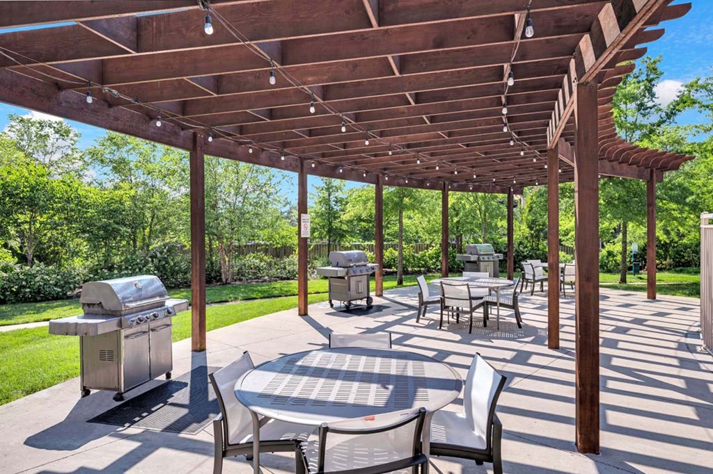a patio with tables and chairs and a pergola