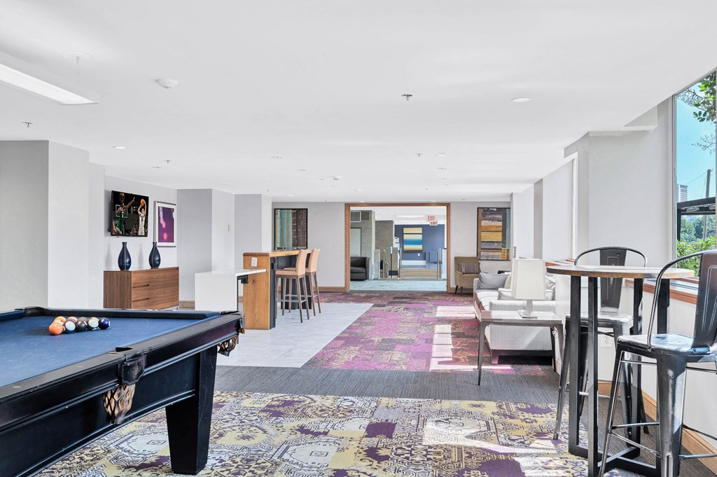 a living room with a pool table and a dining room with tables and chairs