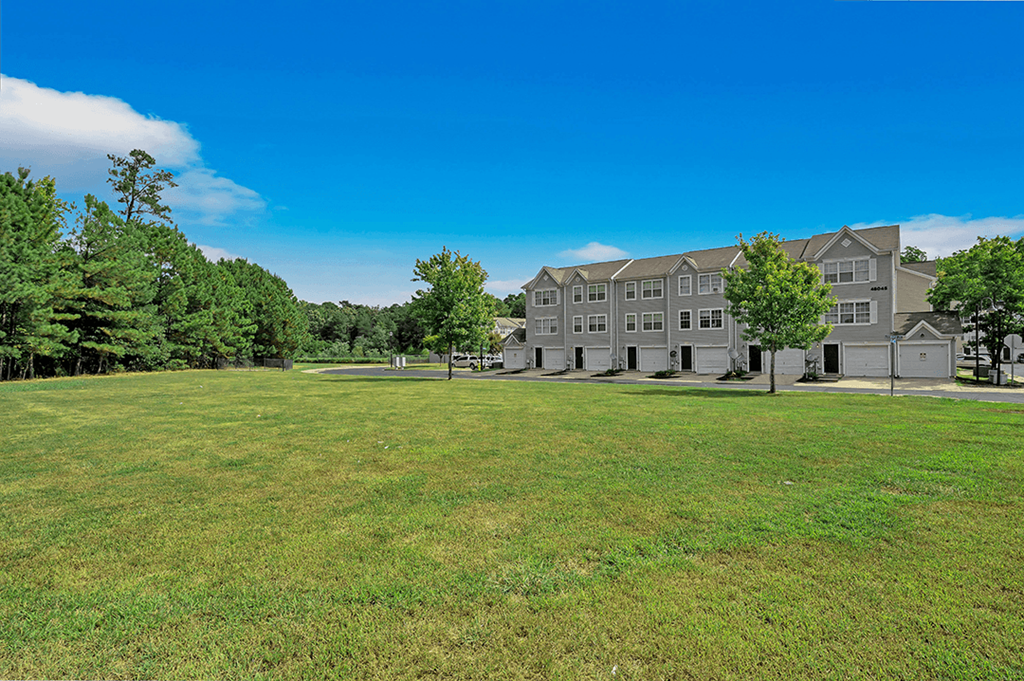 a large grassy area with trees in the background