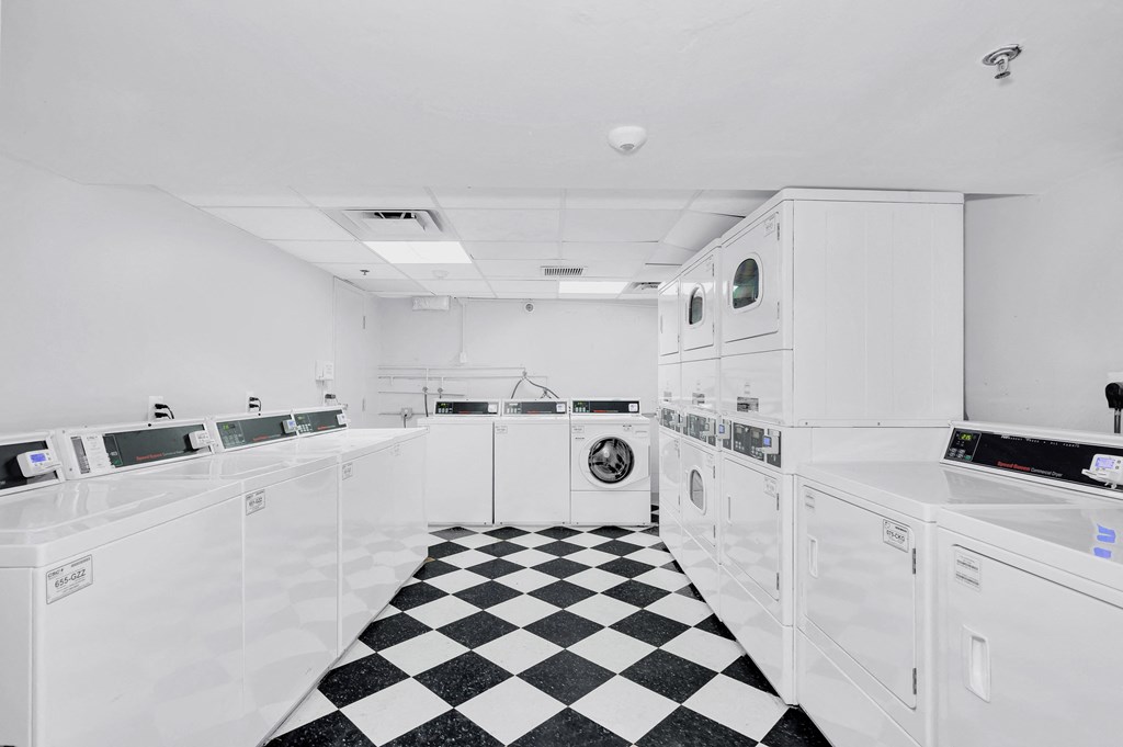 the kitchen has a checkered floor and white appliances