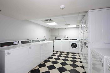 a laundry room with a checkered floor and white appliances