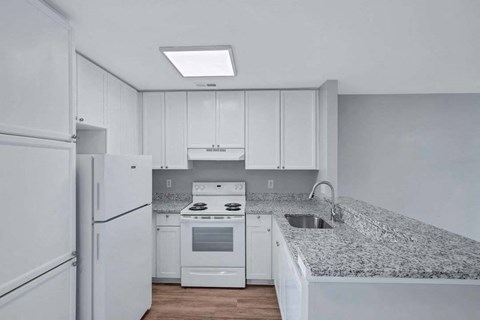 a kitchen with white appliances and granite counter tops