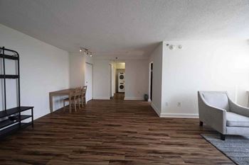 a living room and dining room with wood flooring and white walls