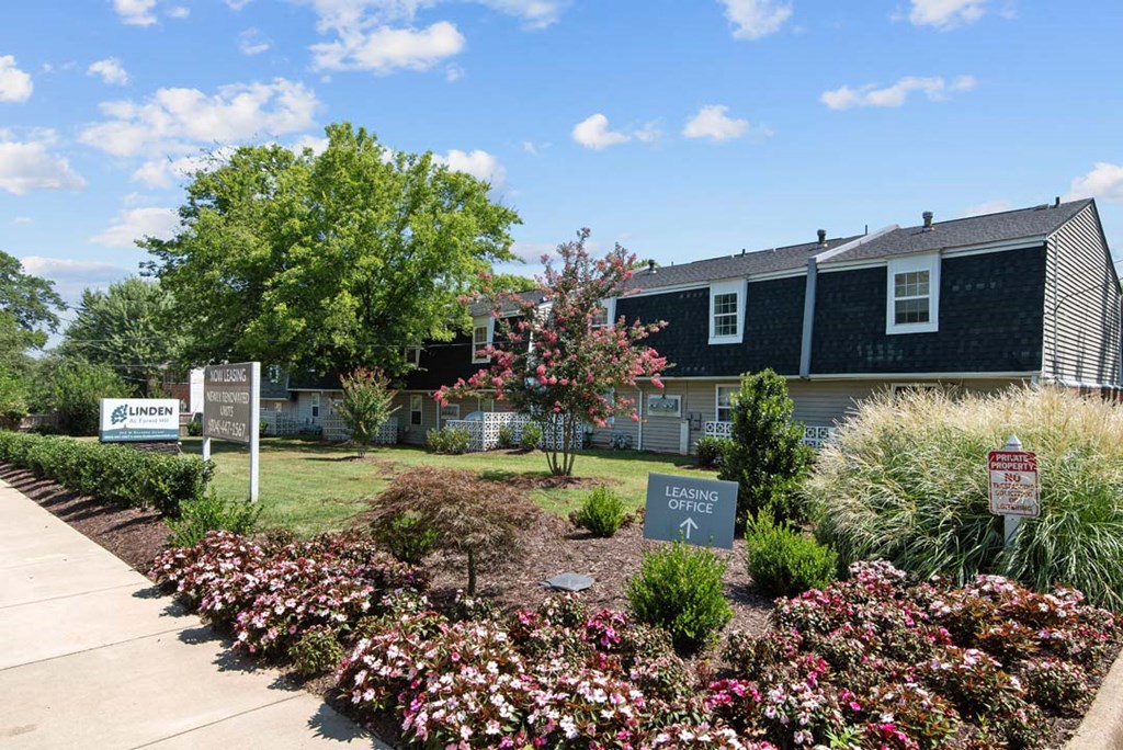the front yard of a house with a garden and signs