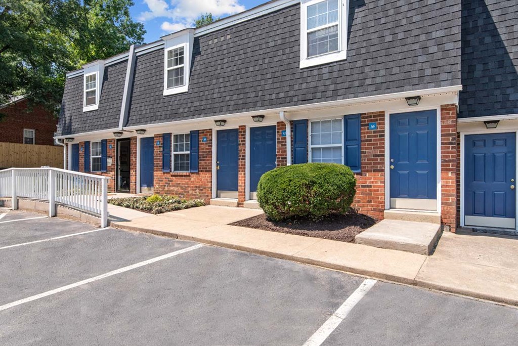 a house with blue doors and a sidewalk in front of it