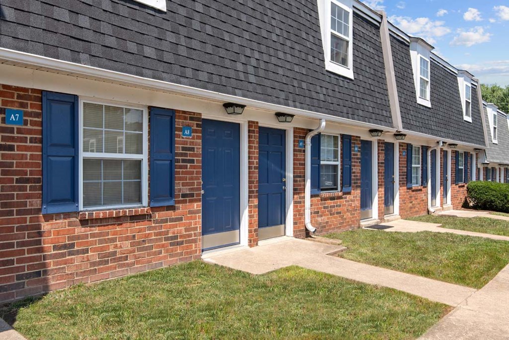 a row of blue doors on a brick building