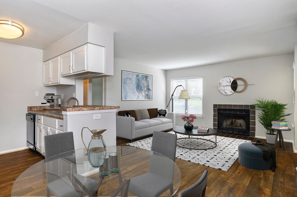 a living room with a glass dining room table and a fireplace