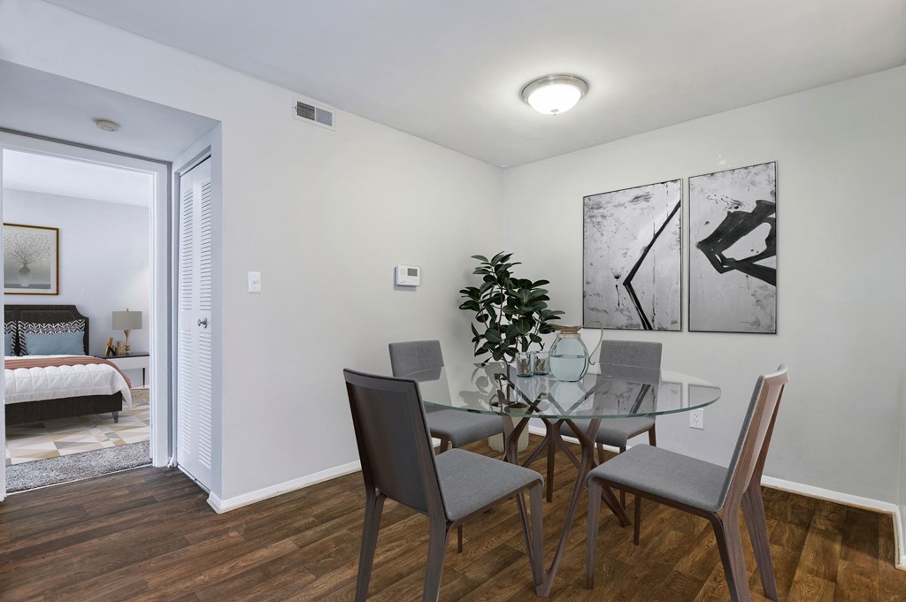 a dining room with a glass table and chairs