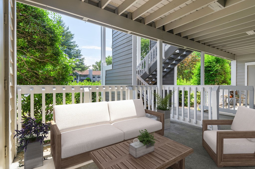 a covered porch with a couch and a table