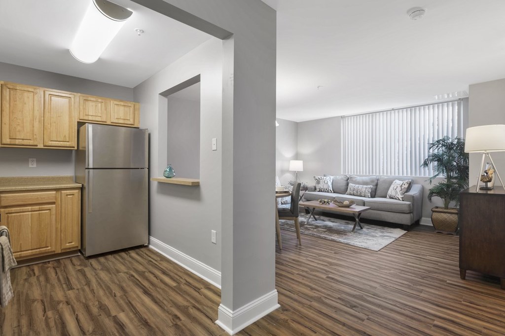 A kitchen with wooden cabinets and a stainless steel refrigerator.