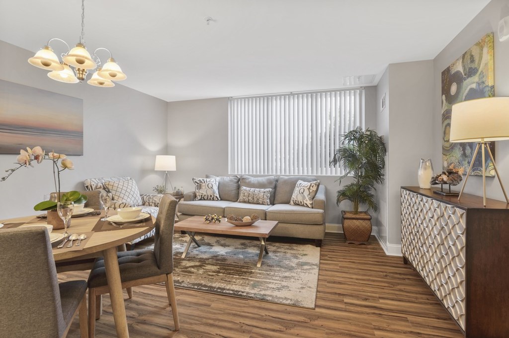 A well-lit living room with a dining table and chairs.