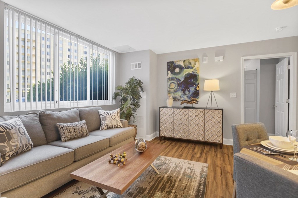 A living room with a grey couch, a wooden coffee table, and a grey rug.