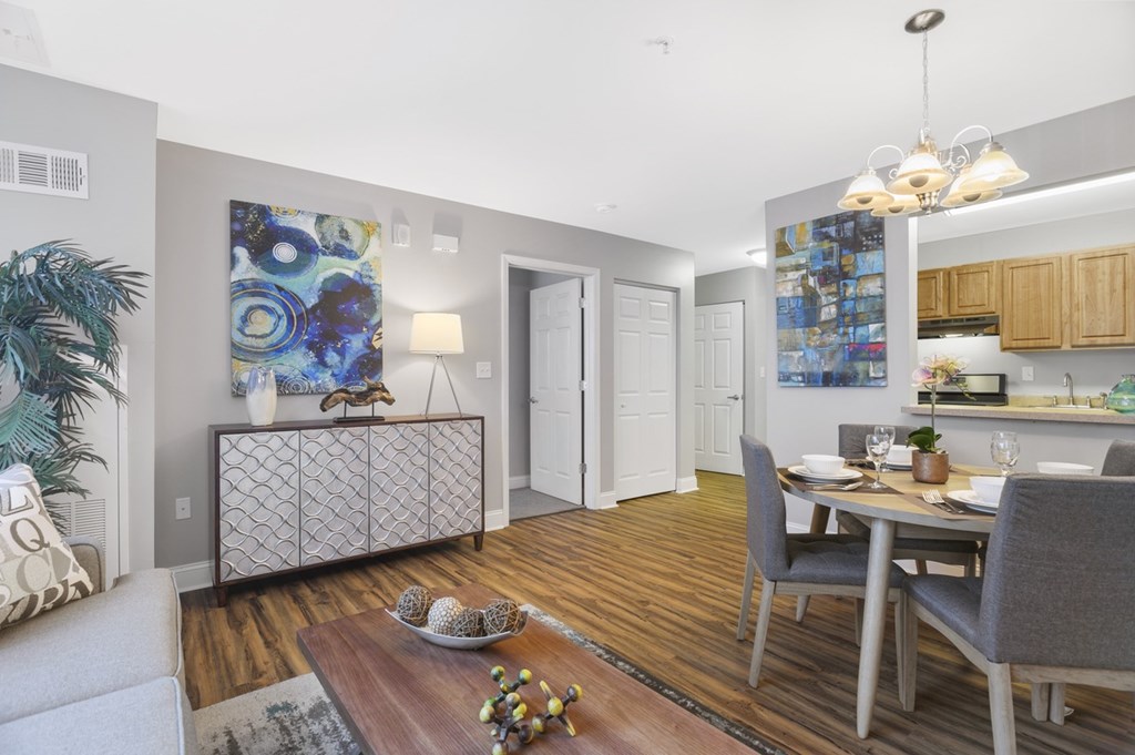 A modern living room with a dining area and kitchen in the background.