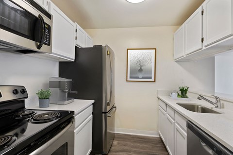 a kitchen with stainless steel appliances and white cabinets