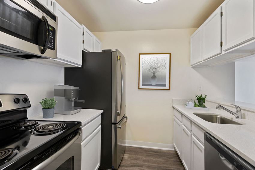 a kitchen with stainless steel appliances and white cabinets