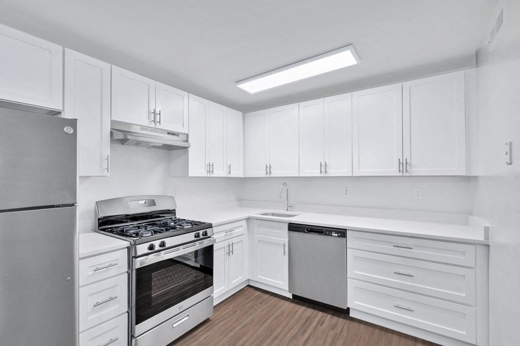 a kitchen with white cabinets and stainless steel appliances