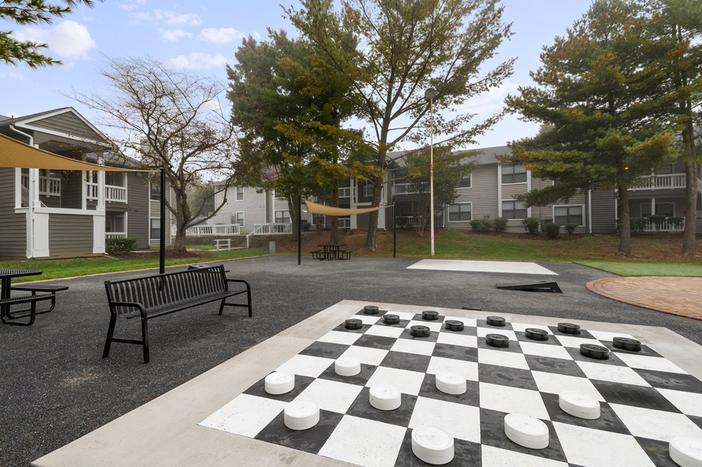 a chess board in a park in front of apartment buildings
