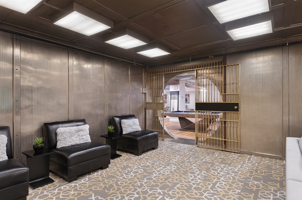 a living room with leather chairs and a spiral staircase
