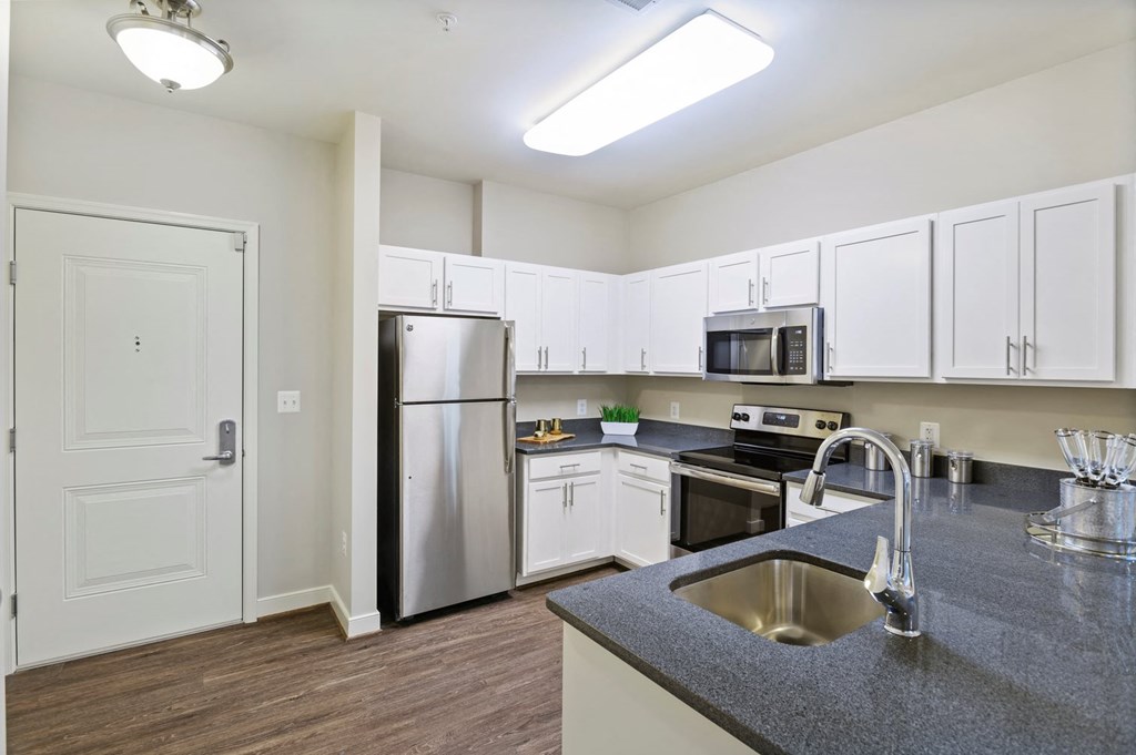 a kitchen with white cabinets and stainless steel appliances
