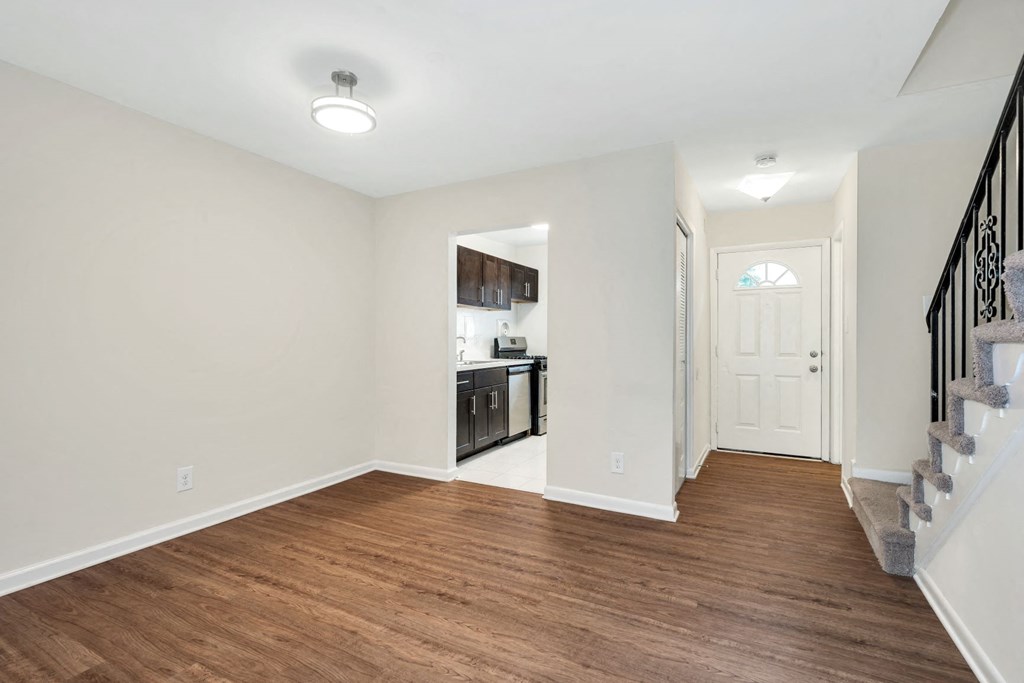 a renovated living room with a hard wood floor and a staircase