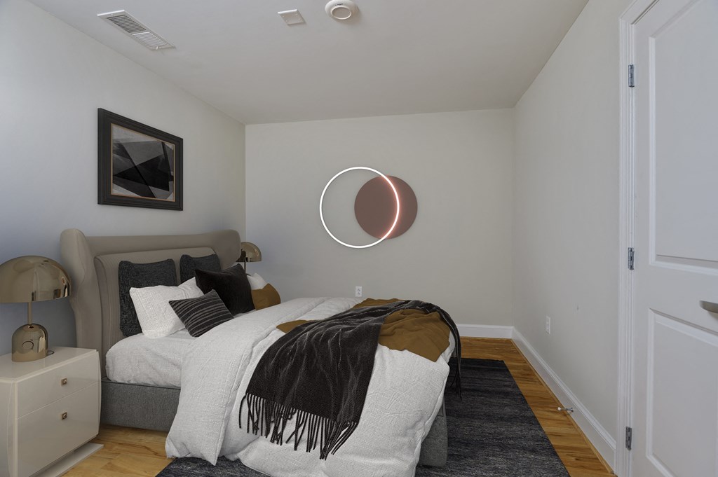 a bedroom with a bed and a circle mirror on the wall