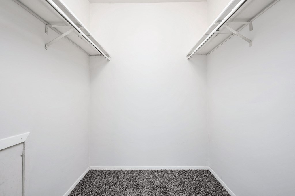an empty room with a carpet and white walls