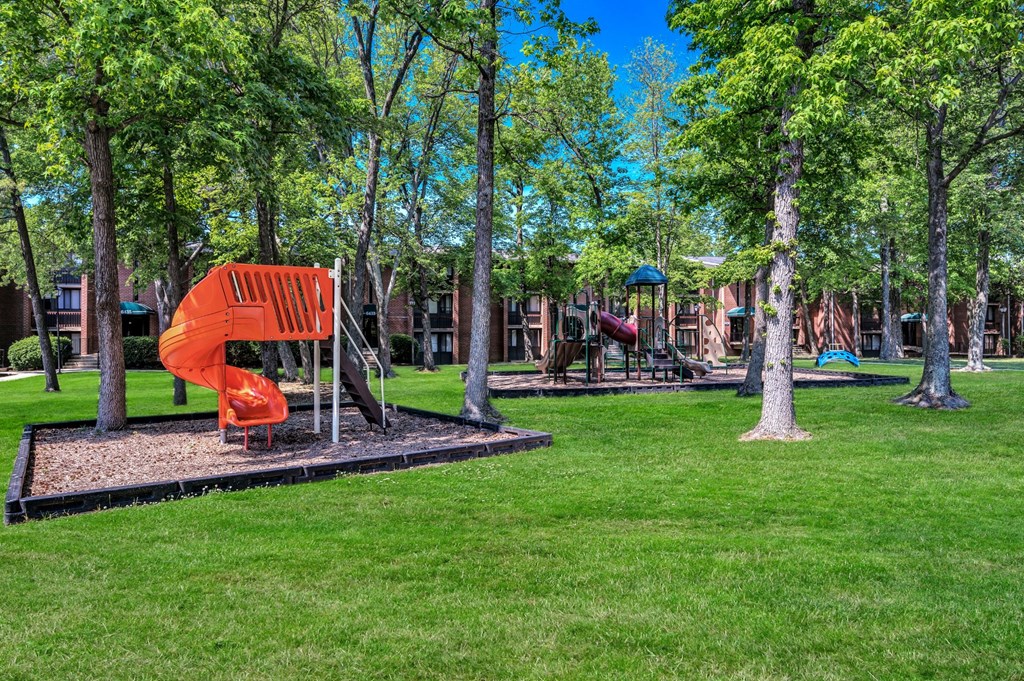a playground with a large orange slide in a park