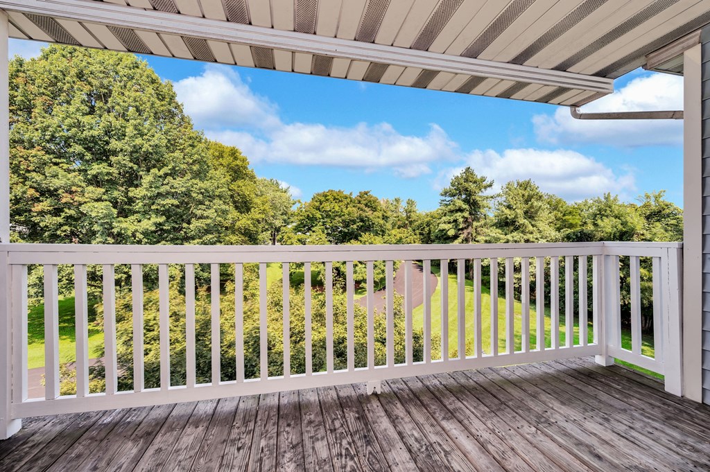 a balcony with a view of a field and trees