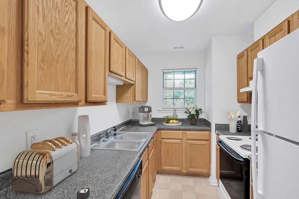 a kitchen with wooden cabinets and granite counter tops and a sink