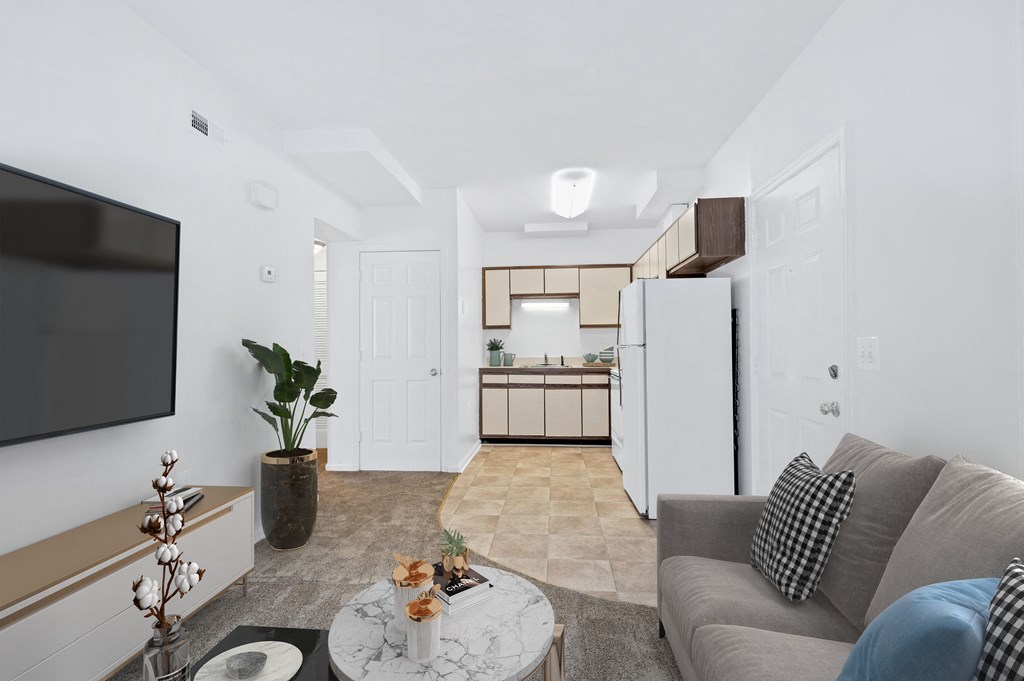 a living room and kitchen with a couch and a table