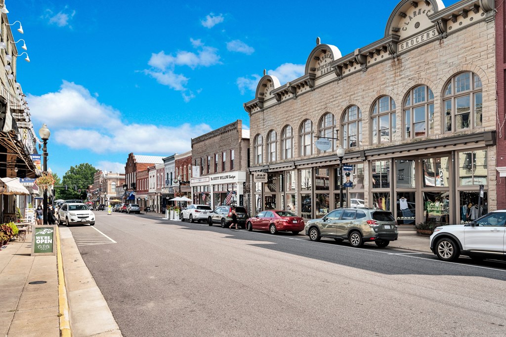 a city street with cars parked in front of a brick building