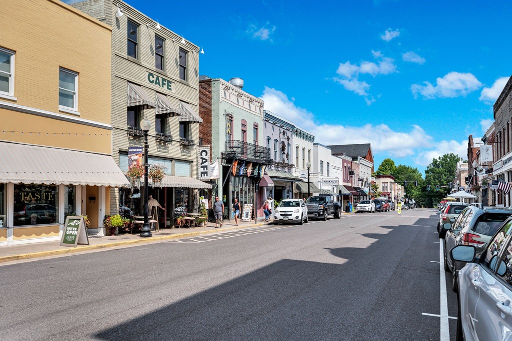 a city street with cars parked on the side of the road and buildings