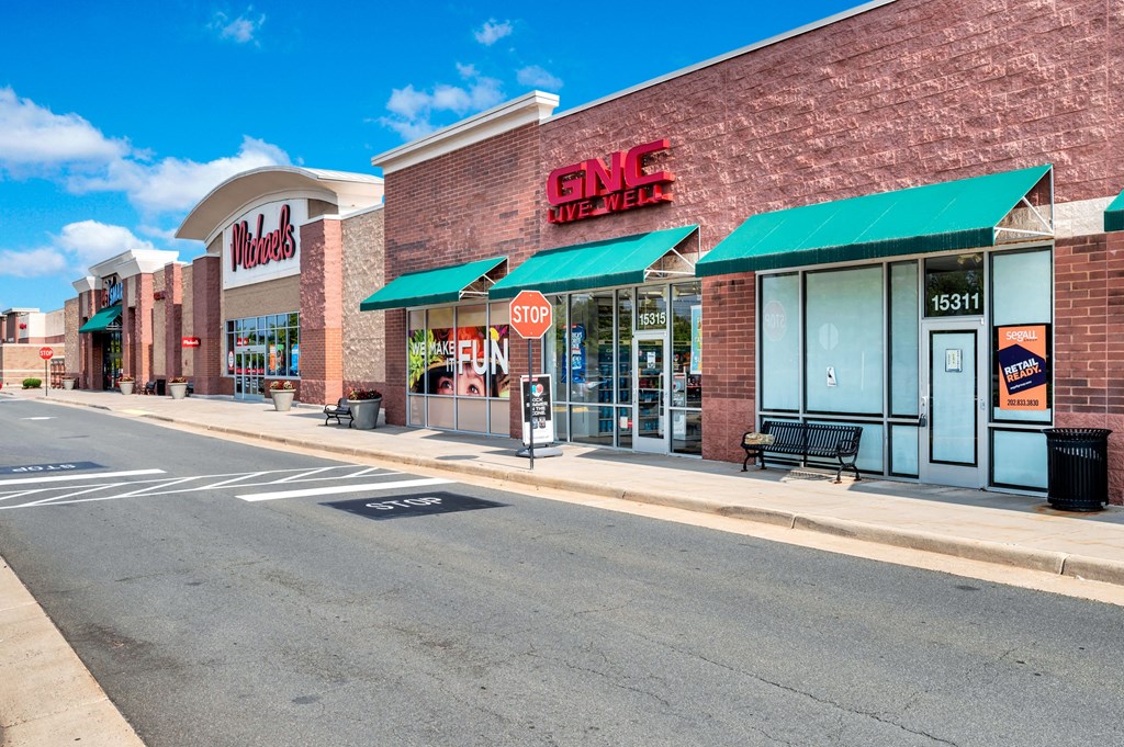 a city street in front of a grocery store with a stop sign